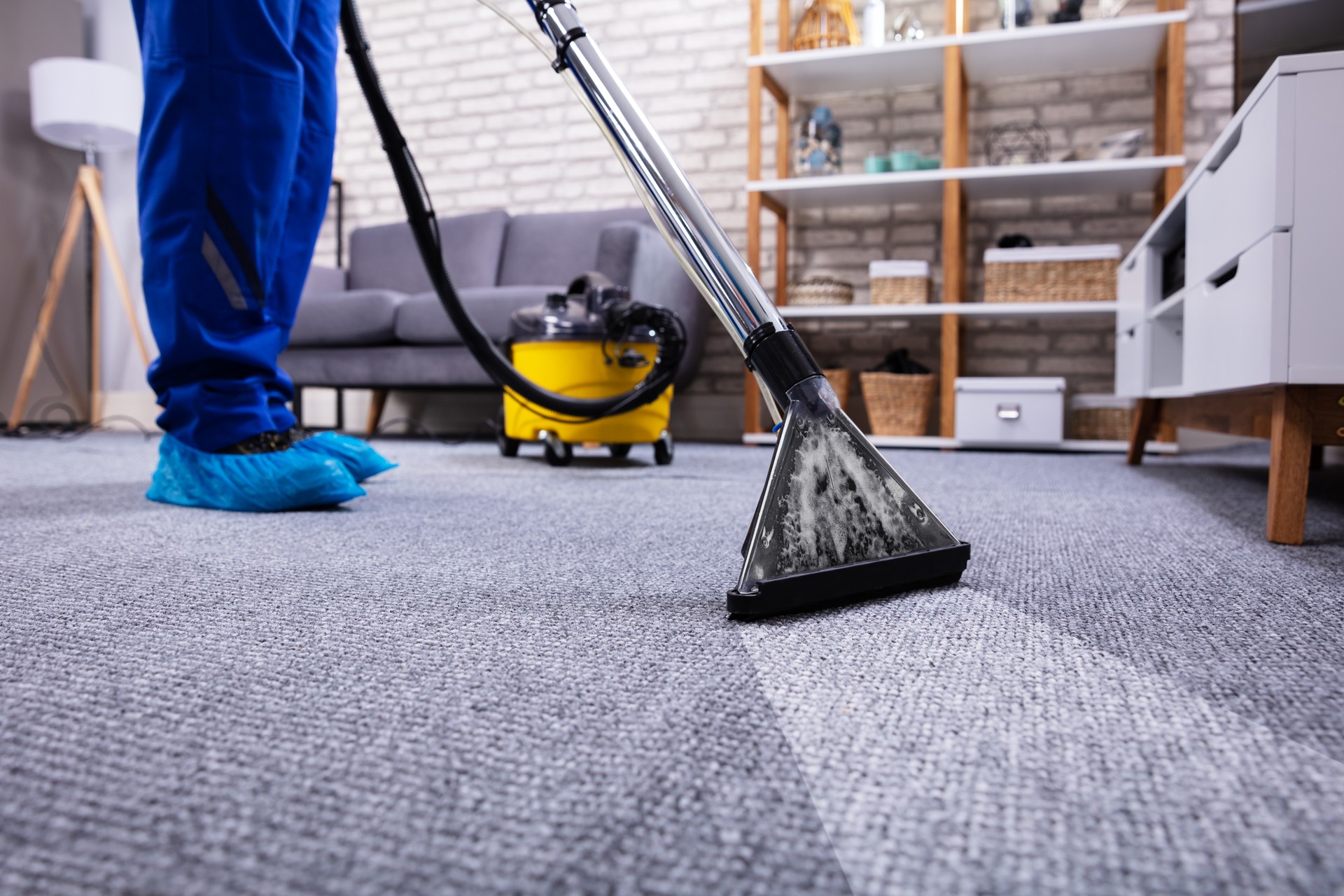 Person Cleaning Carpet With Vacuum Cleaner